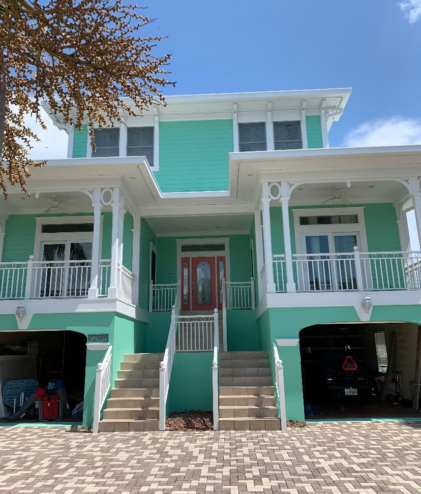 Two-story coastal-style home with fresh siding, trim, and front entry.