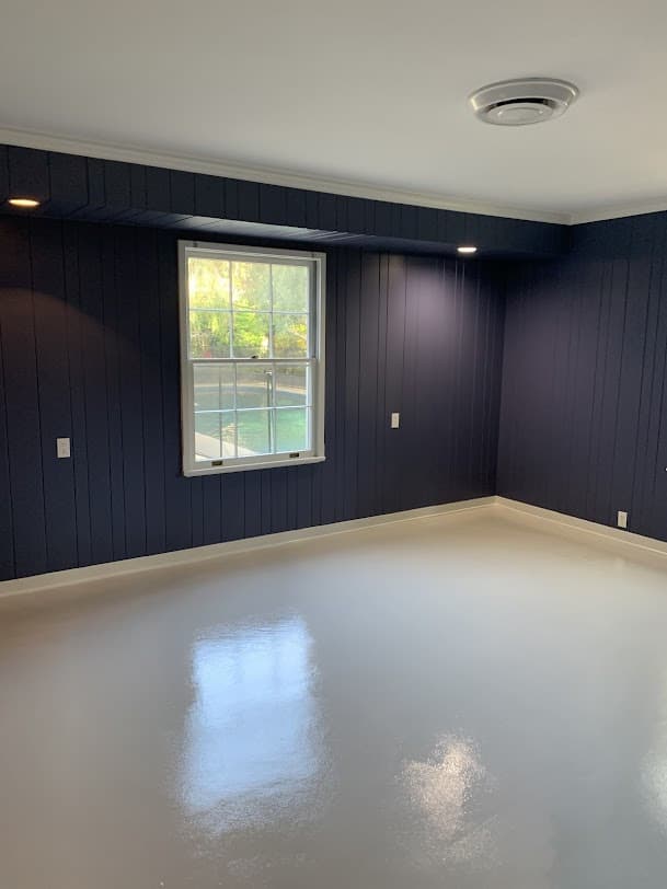 Finished interior room with painted paneled walls, trim, and glossy floor.